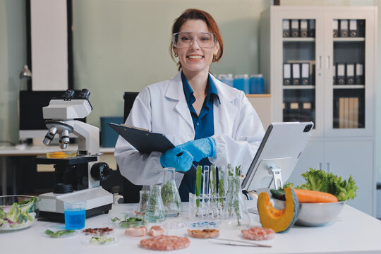 Scientists in lab coats work with plants in a modern lab, focusing on research and experimentation under bright, sterile conditions.