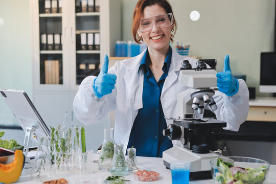 Scientists in lab coats work with plants in a modern lab, focusing on research and experimentation under bright, sterile conditions.