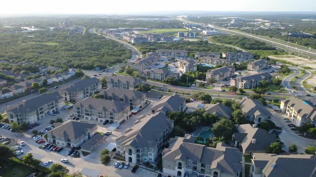 Modern apts stretch across Westover Hills district toward distant theme park skyline. Overhead perspective details suburban community development across Bexar County, San Antonio, Texas