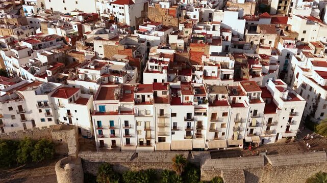 Aerial tilt view of Peniscola old town white houses and castle in Valencian region, Spain. High quality 4k footage