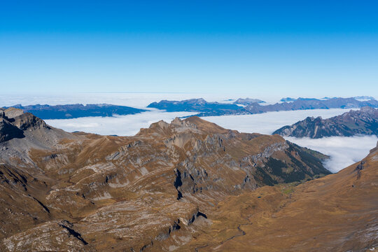 Schilthorn observation deck panoramic aerial view of Eiger, Monch, Jungfrau mountains and sea of clouds above Murren village. Lauterbrunnen, Canton of Bern, Switzerland.