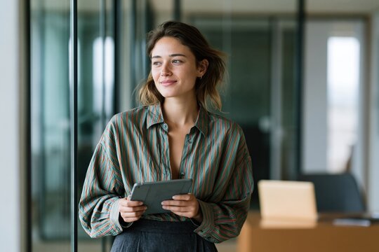 Young professional woman holding tablet in a modern office background for business portrait and corporate website banner