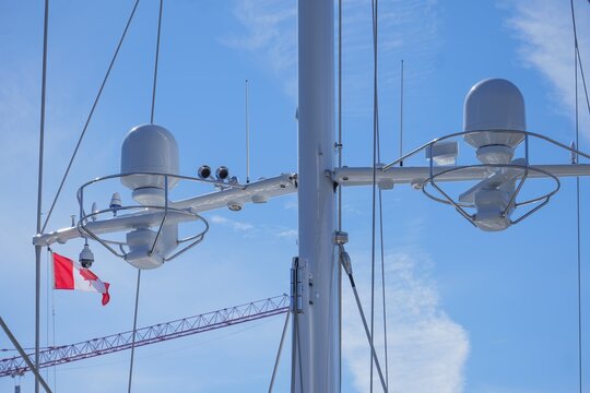 Satellite radome domes and marine radar on luxury yacht mast with Canadian flag