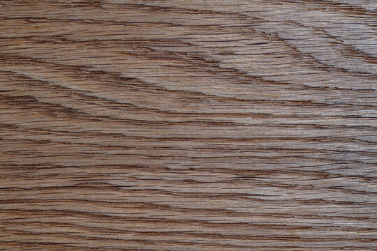 Closeup of dark brown wooden surface texture with natural grain patterns ideal for design backgrounds and interior concepts