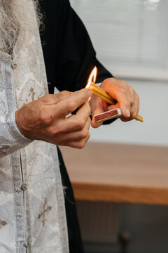 Orthodox priest lighting a beeswax candle