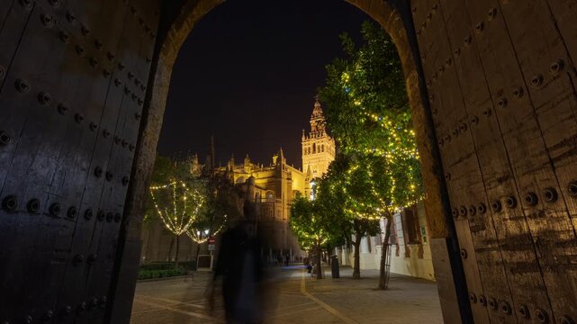 Night timelapse of the Giralda and Seville Cathedral illuminated during Christmas in the historic center of Seville