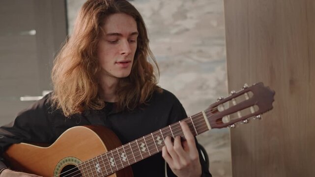 Young guitarist teaching classical pieces in cozy studio, guiding student through fingerstyle technique, closeup on hands, warm natural light, attentive expression, acoustic guitar ornate rosette