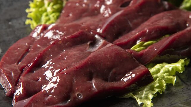 Fresh sliced beef liver with lettuce for premium Japanese barbecue preparation and grilling