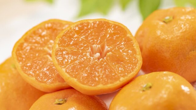 Mandarin oranges cut in half showing the juicy segments, camera zooms in and pans across the fruit