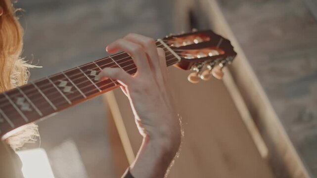 Bright guitar lesson. Caucasian instructor guides student. Sunlit studio showcases coaching specific techniques. Teacher provides gentle guitar instruction in sunlit loft studio setting