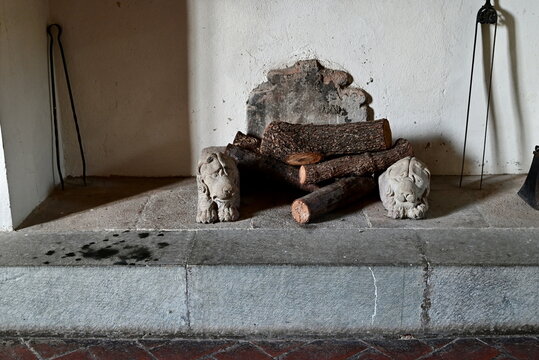 Front View of Ancient Stone Fireplace with Carved Lion Dogirons and Firewood in Bologna Italy for Interior Design