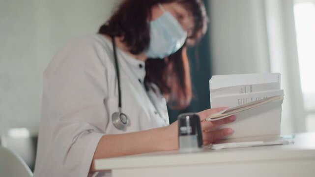Healthcare administrator sorting patient documentation diligently. Medical administrator efficiently organizing and processing paperwork while maintaining professional focus in clinical environment