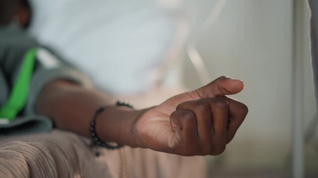 Nurse monitoring infusion on patient wrist, green strap and iv tubing in frame, hospital ward background blurred, attentive touch, steady pulse tracking, compassionate bedside care, warm tones
