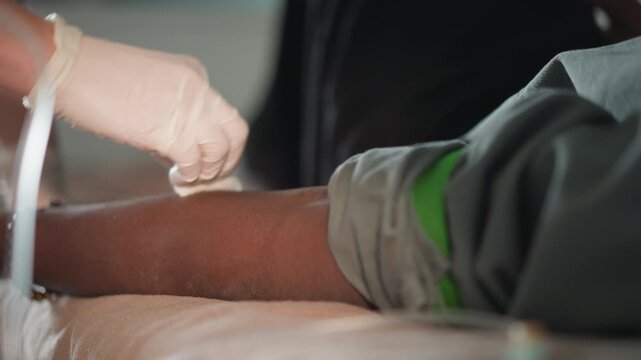 Homemade healthcare blood collection. Skilled nurse guides needle into vein accurately and safely. Professional healthcare worker performs sterile blood collection under home care conditions