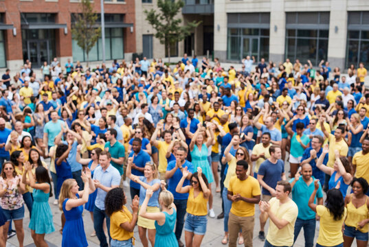 Large diverse crowd of people clapping and cheering together in an outdoor urban city plaza