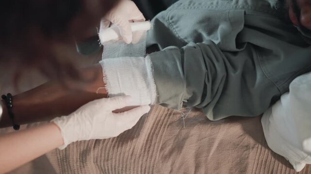 Careful application of bandage. Overview of medical tasks including precise bandage placement. Detailed description of nurse performing careful and textured bandage application procedure