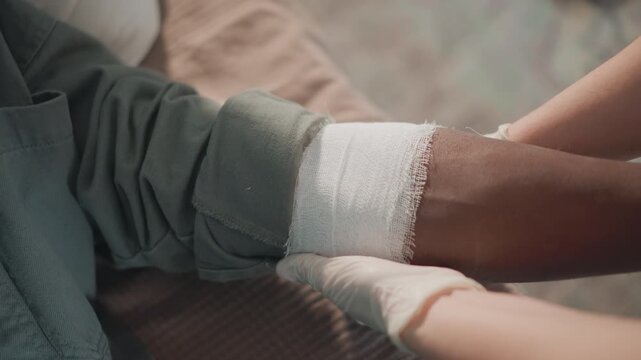 Careful wound treatment. Nurse dressing injury carefully. Medical professional attentively managing patient wounds. Skilled healthcare worker applying sterile bandages with precision and compassion