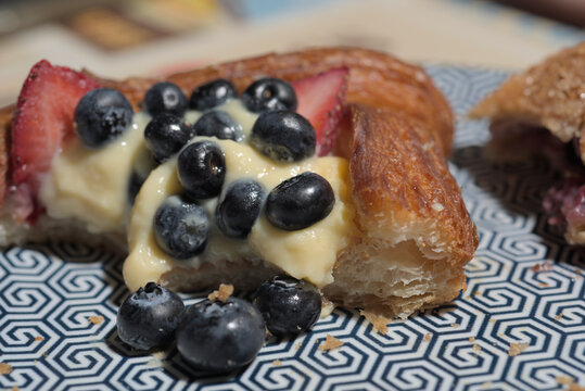 Gourmet fruit tart danish with vanilla pudding cream on a patterned plate