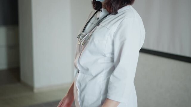 Wide shot nurse holding medical case, white caregiver wearing mask and stethoscope, walking into living room, clear first aid box in hand, ready for patient visit, covidsafe precautions