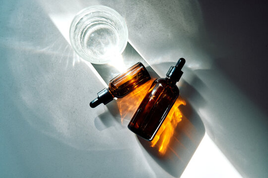 Amber glass dropper bottles catching sunlight refraction