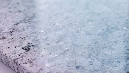 Fototapeta premium Close-up texture of a speckled granite countertop with a soft gradient of blue and purple hues