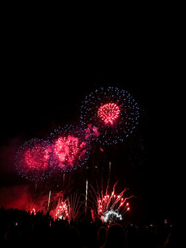 Red and blue fireworks exploding over crowd at 22 July Cannes