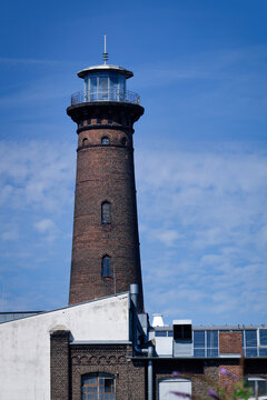 The historic Helios lighthouse in Cologne-Ehrenfeld district. Iconic brick tower and industrial monument under a blue sky