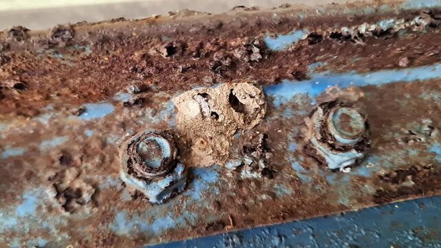 Heavy Corrosion and Rust on Metal Structure with Peeling Blue Paint and Rusty Fasteners