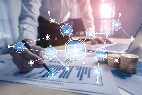 A businessman is analyzing financial data trends, surrounded by digital icons representing growth and investment strategies, illustrating a modern analytical workspace. Tessel