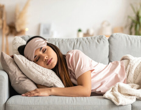 Sleeping woman eye mask sofa pillow blanket home comfort relaxation rest pajama create calm peaceful scene of cozy afternoon nap in soft light living room Christmas concept