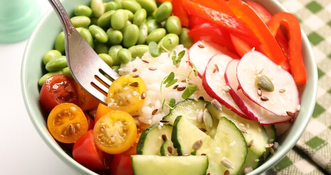 High fiber food. Taking tasty salad, rice and seeds from bowl at light table, closeup
