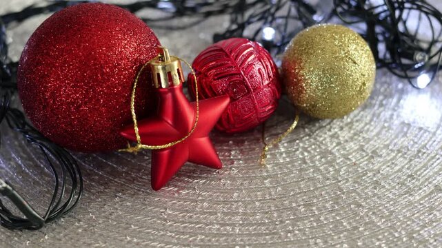 Una toma de cerca de bolas y adornos de navidad de varios colores con luces de navidad en un fondo negro
