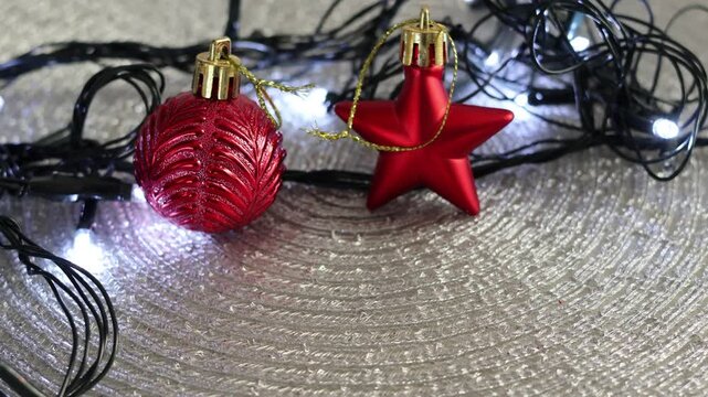 Una toma de cerca de bolas y adornos de navidad de varios colores con luces de navidad en un fondo negro