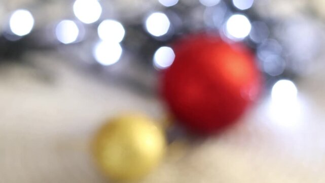 Una toma de cerca de bolas de navidad de varios colores con luces de navidad con desenfoque en un fondo negro. 