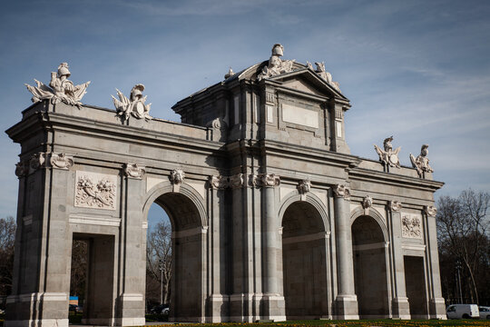 Puerta de Alcala at Plaza de la Independencia, showing the monumental neoclassical stone gateway with five openings, columns, arches and sculptural decoration against a clear sky in Madrid, spain.