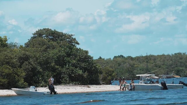 Boats docked on beach with trees and lake