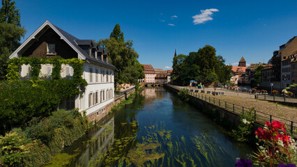 Fototapeta premium Historic buildings lining the tranquil canal in the charming Petite France district of Strasbourg, France