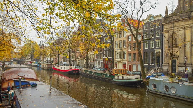 Autumn canals of Amsterdam with houseboats and Dutch houses, panoramic view with copy space