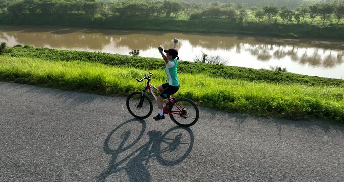Riding bike without holding the handlebar on beautiful country road