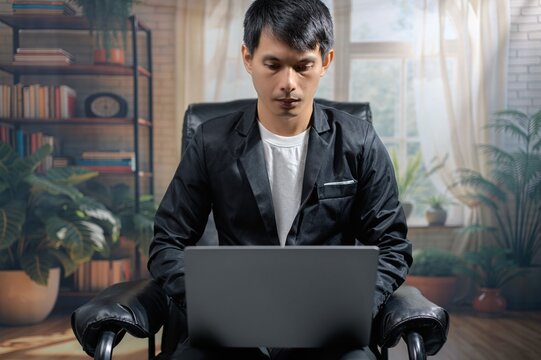 Young Man Working on Laptop in Cozy Home Office Environment