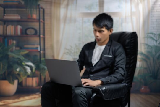 Young Man Working on Laptop in Cozy Home Office Environment