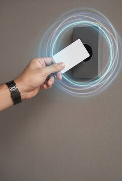 Hand holding blank access card near electronic reader for entry