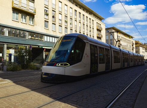 STRASBOURG, FRANCE - AUGUST 6, 2026 - Modern tram riding on rails through an urban street in Strasbourg, France