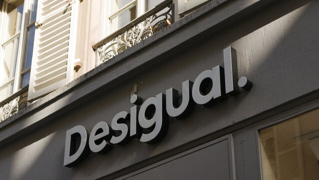 STRASBOURG, FRANCE - AUGUST 6, 2026 - Desigual brand logo illuminating a storefront in a European city street