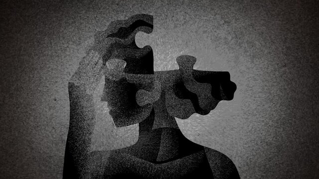 silhouette of a woman constructing her head from jigsaw puzzle pieces