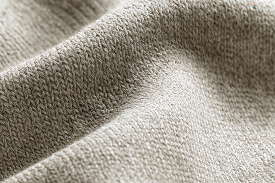 Knit fabric texture close up soft wool textile beige sweater ribbed pattern warm clothing material textile background macro detail