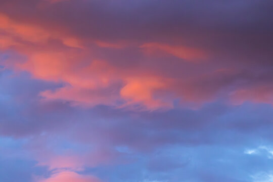 Colorful sunset sky with vibrant pink and purple clouds illuminated by the setting sun, creating a dramatic and picturesque atmosphere in the evening sky