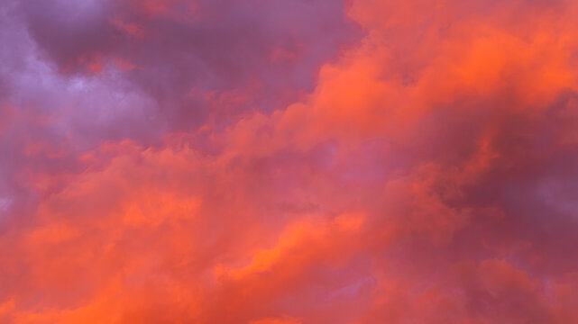 Vibrant sunset sky with dramatic clouds displaying shades of orange, pink, and purple, creating a stunning natural landscape background