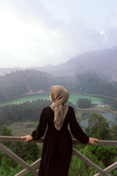 Young asian women enjoying Beautiful view of Telaga Warna from Batu Ratapan Angin, Dieng, Central Java, Indonesia