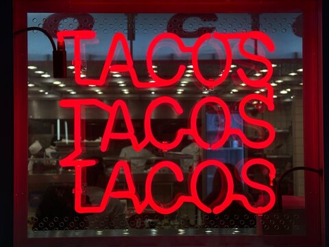 Letrero de ne&oacute;n rojo con la palabra tacos en un restaurante